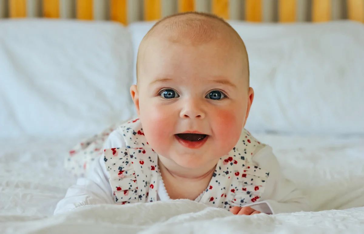 Smiling baby lying on her stomach