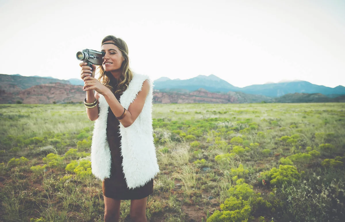 woman filming in rural field
