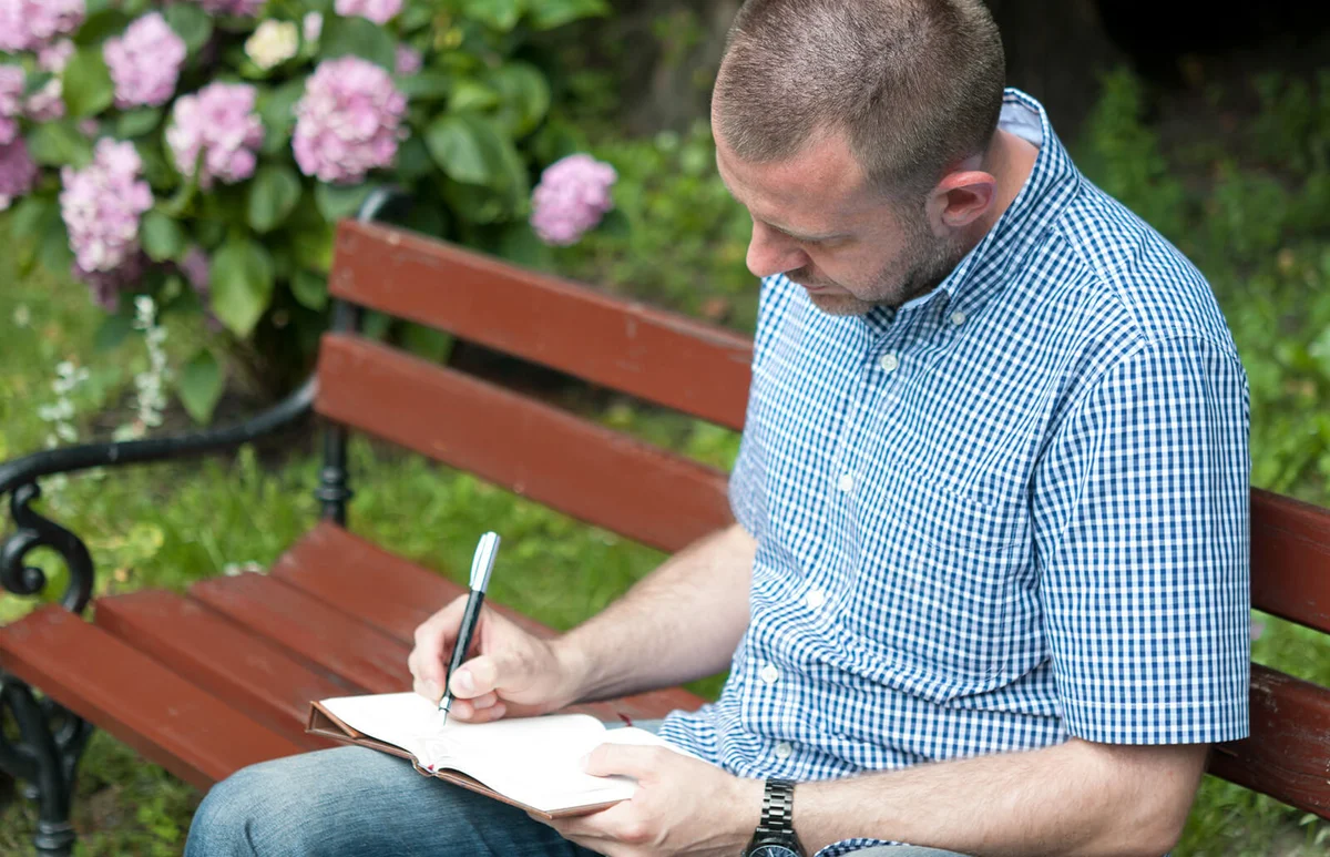 man writing in a notepad