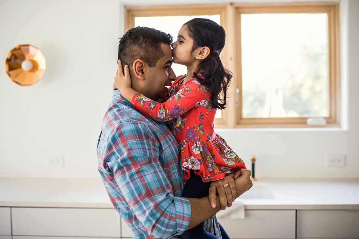 Daughter kissing father at home