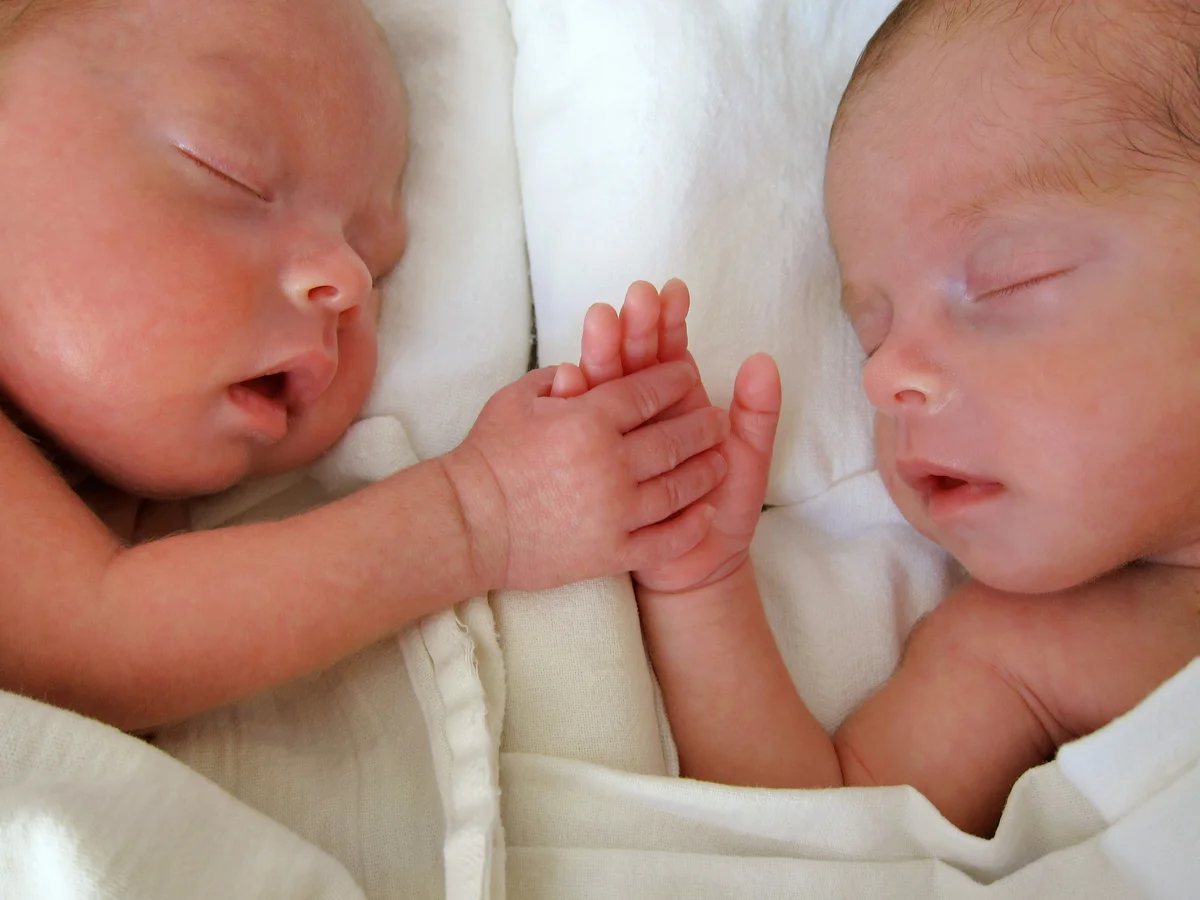 Newborn Premature Twins holding hands