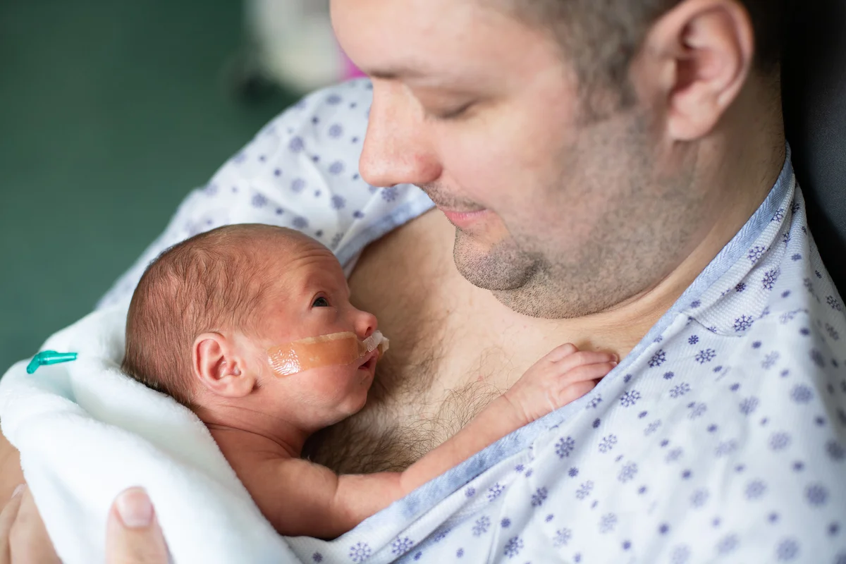 Father holding his premature baby doing skin to skin