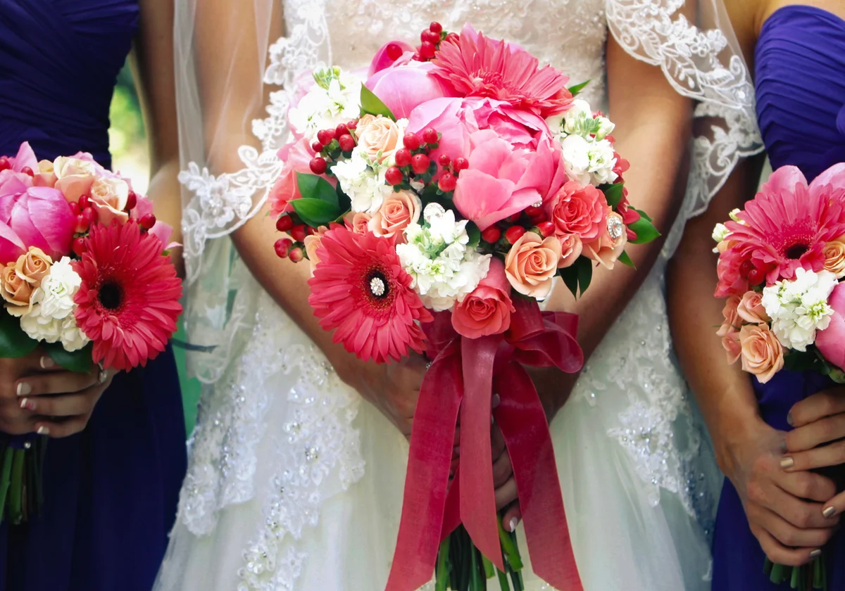 Bride with bridesmaids holding gerber daisy bouquets