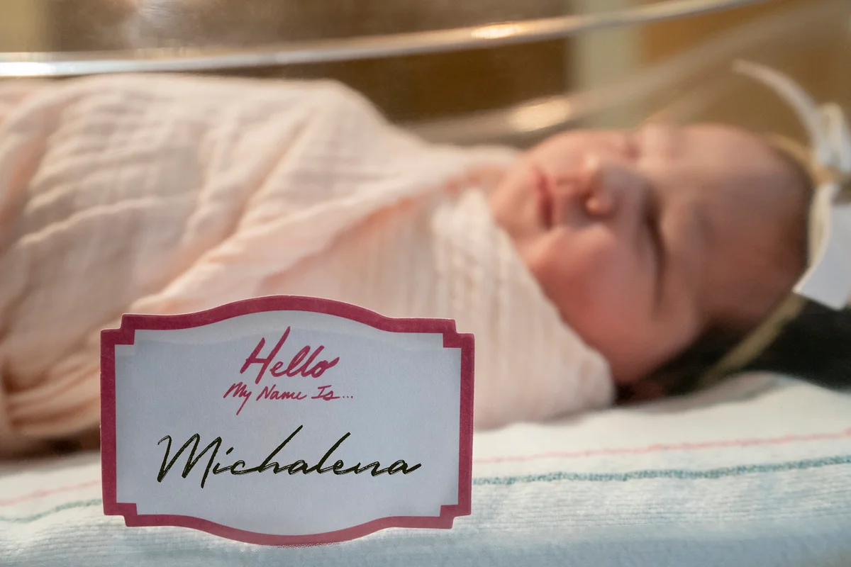 newborn baby girl with tag my name is