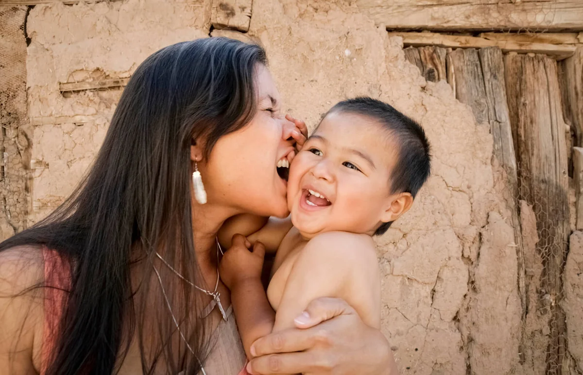 Playful mother holding son outdoors