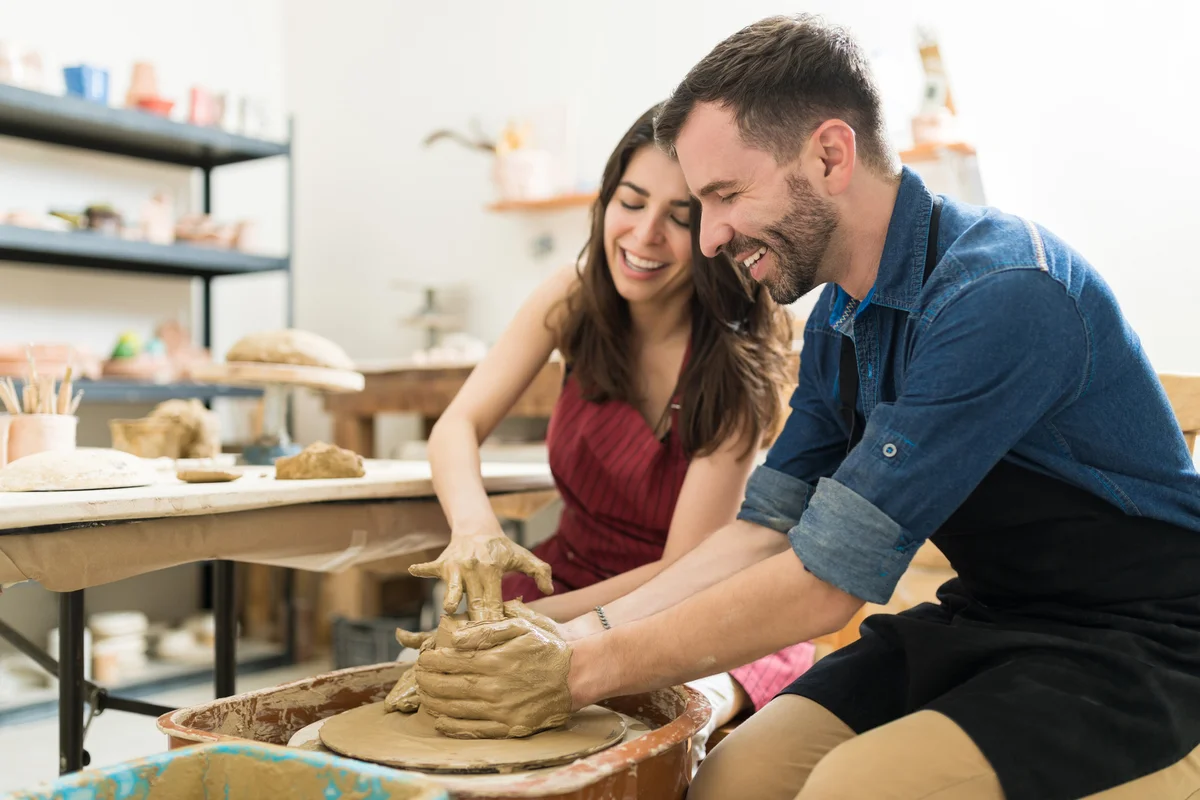 Couple Showing Their Creativity While Dating In Pottery Class