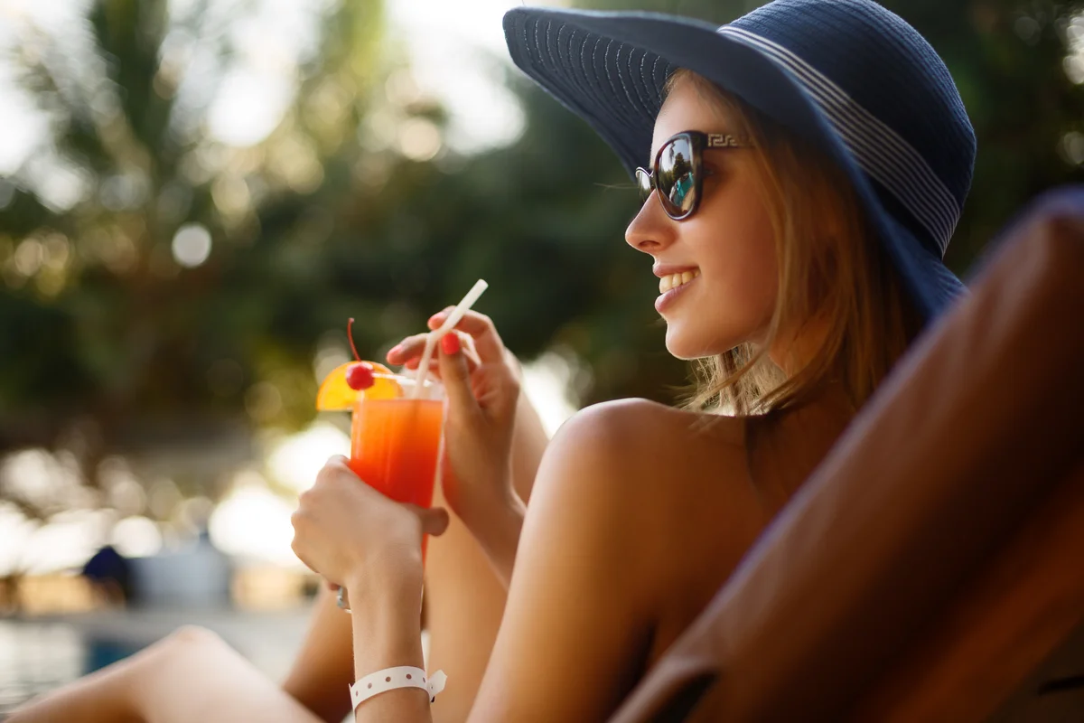 Woman enjoying a mocktail by the pool