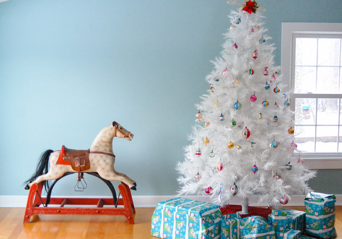 Antique rocking horse and white Christmas tree