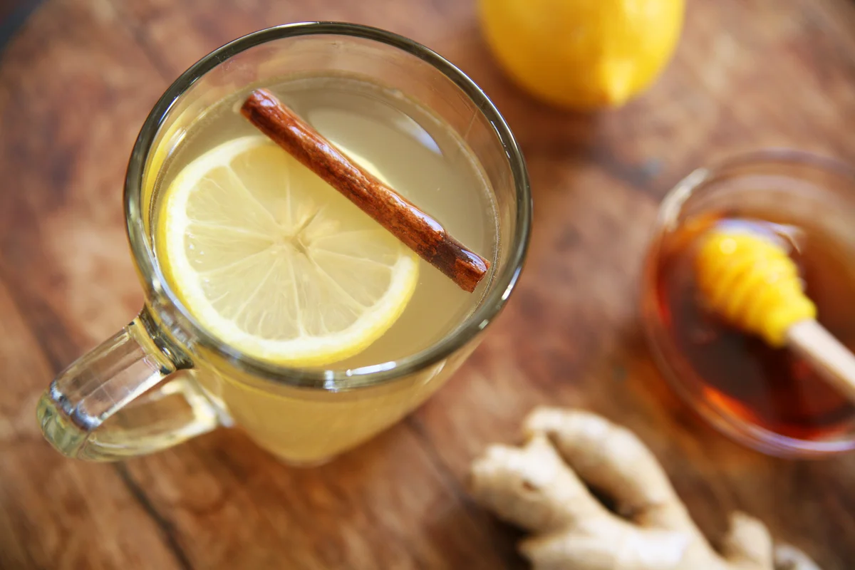 Hot whiskey toddy drink with lemon, honey, cinnamon, and ginger