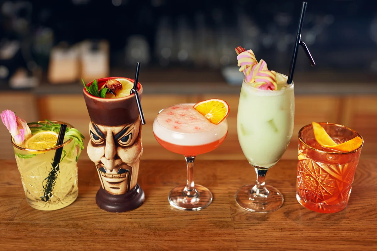 Tiki drinks lined up on a bar
