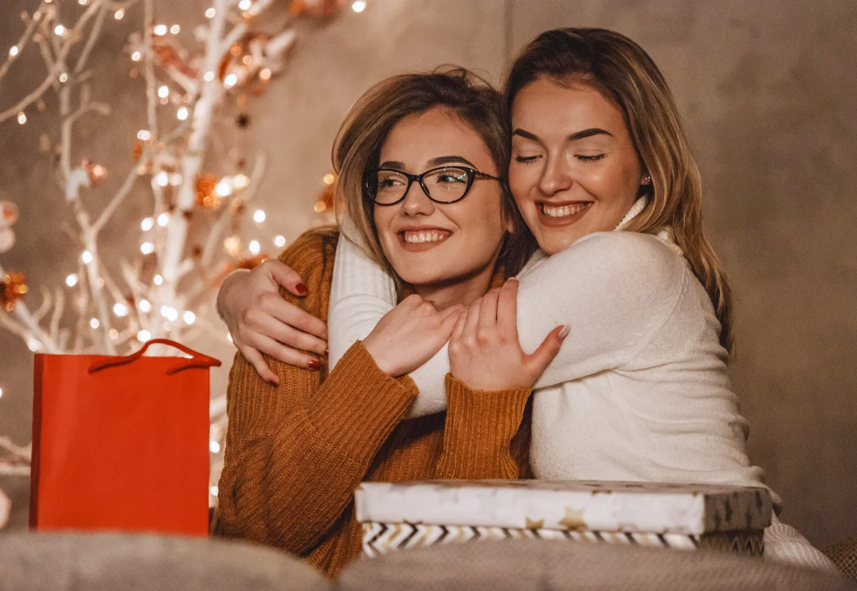 Sisters hugging near the Christmas tree