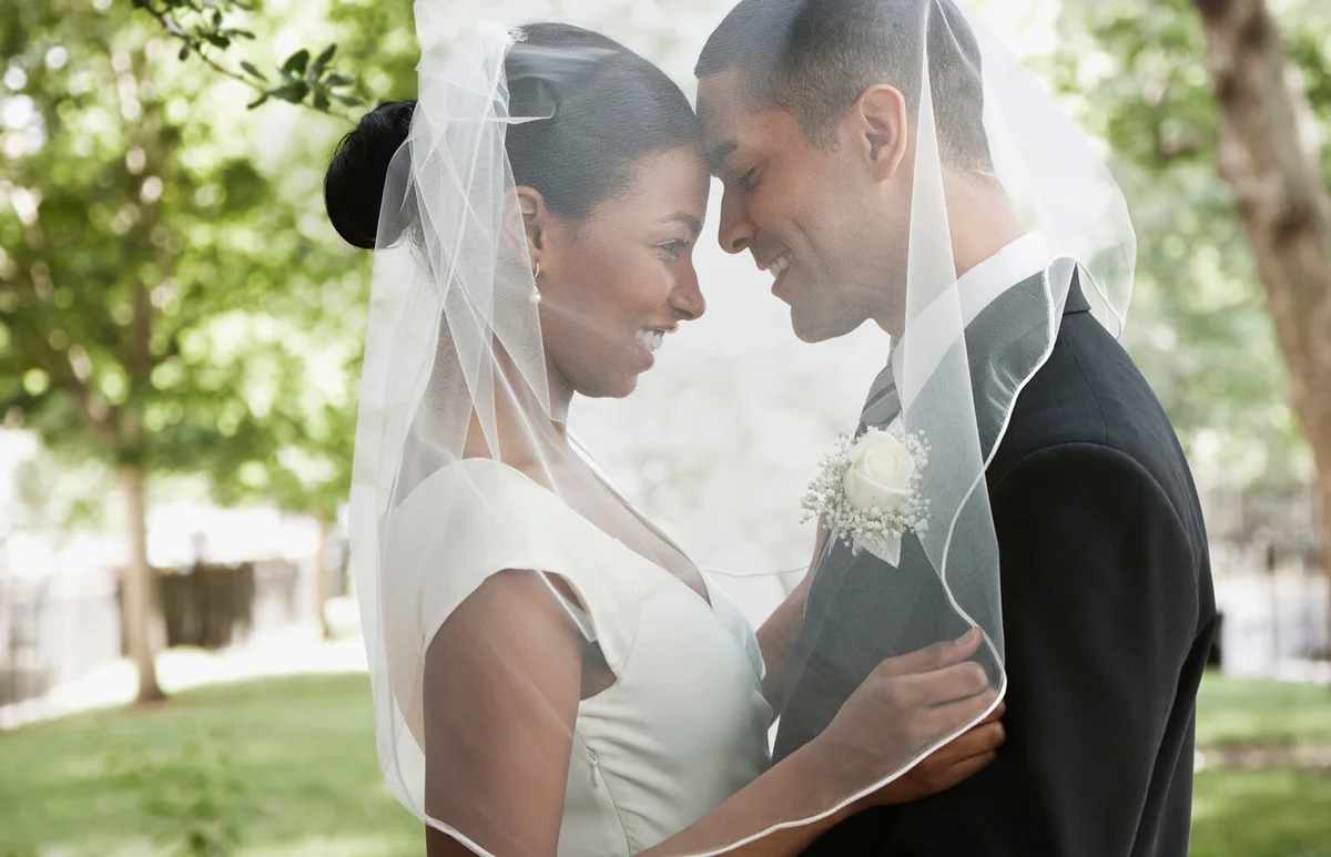 Bride and groom hugging under veil