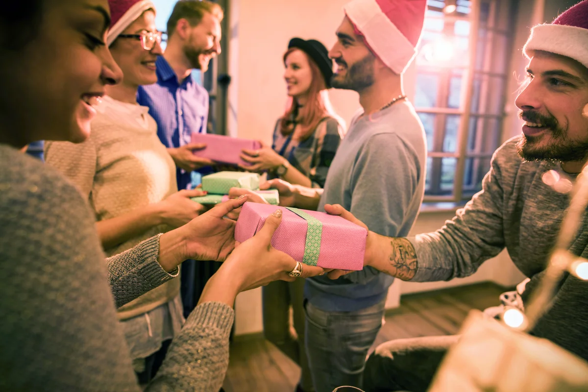 Large group of colleagues exchanging Christmas gifts