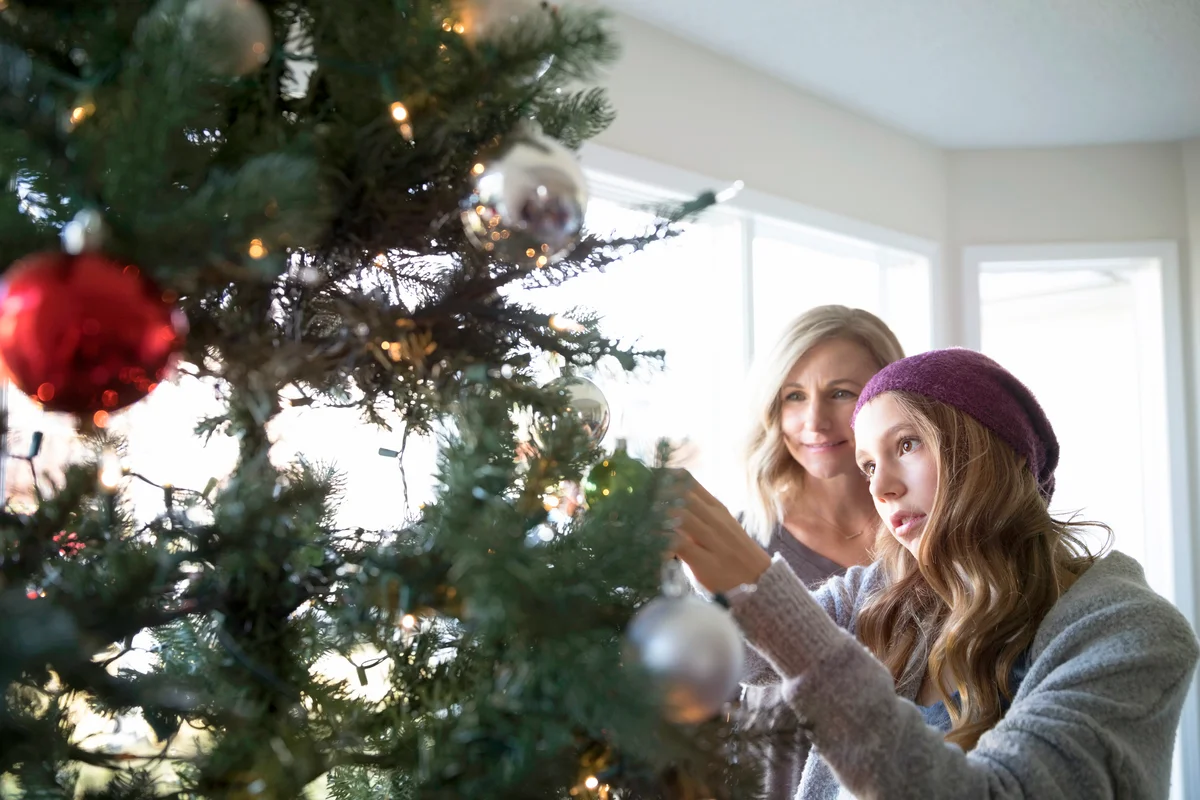 Mother and daughter decorating Christmas tree