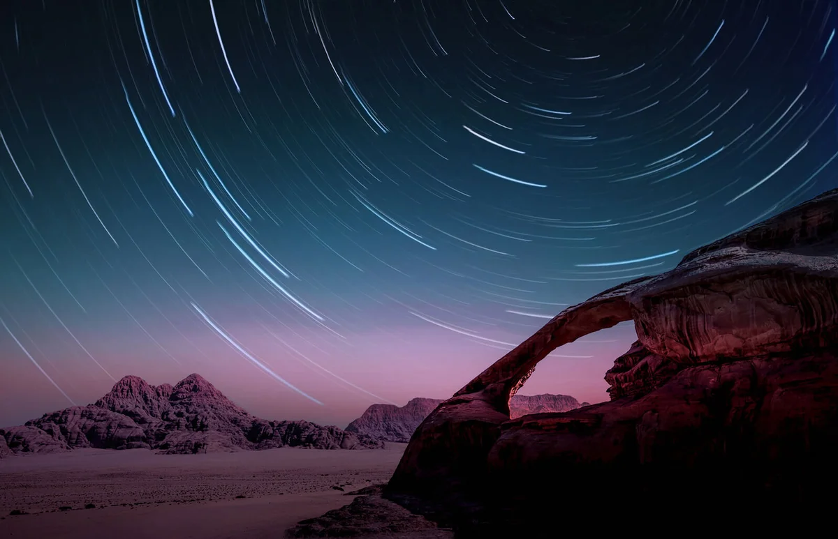 stars in the Wadi Rum desert of Jordan with natural arch