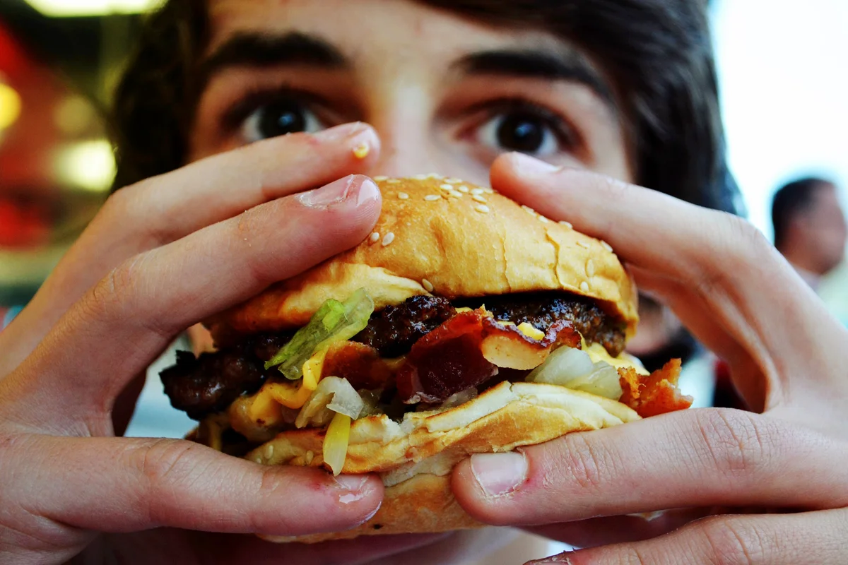 Teenage Boy Eating Hamburger