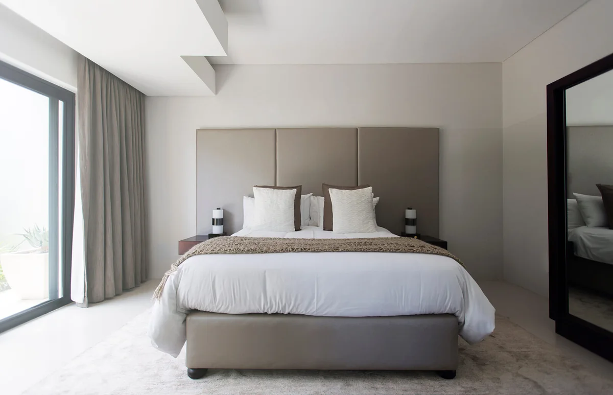 Modern white and beige bedroom with double bed