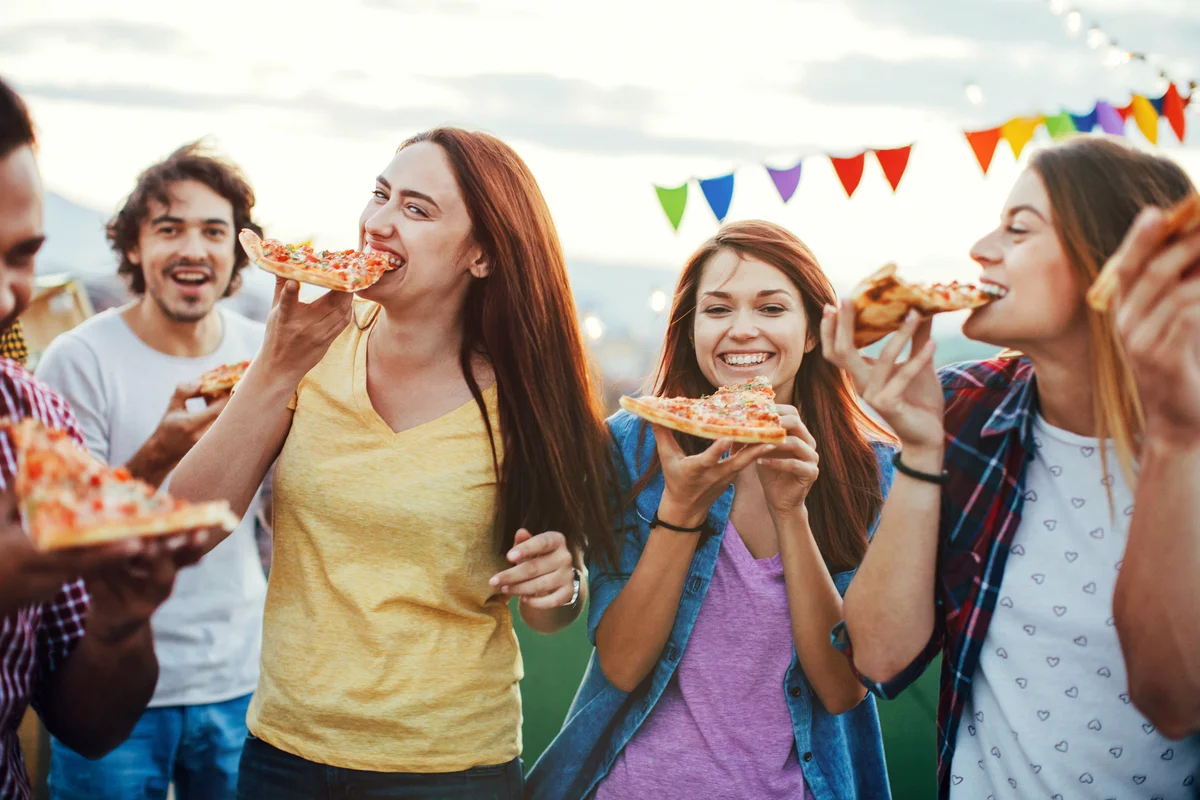 Hungry friends eating pizza