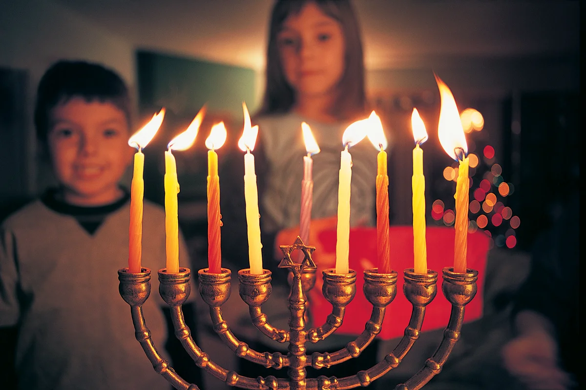 Brother and Sister Watching Candles Burning on a Menorah During Hannukah
