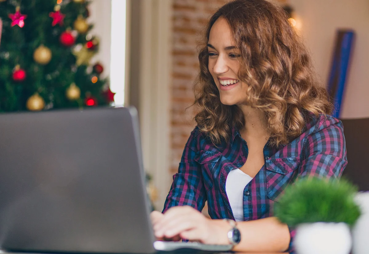 Woman on laptop writing Christmas newsletter