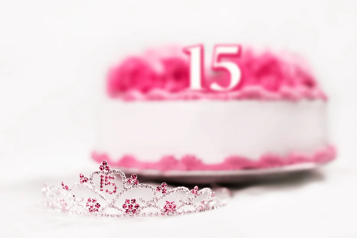 A tiara worn by a girl celebrating her 15th birthday is shot in front of a birthday cake