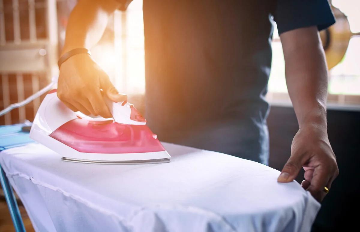 Man Ironing Shirt At Home