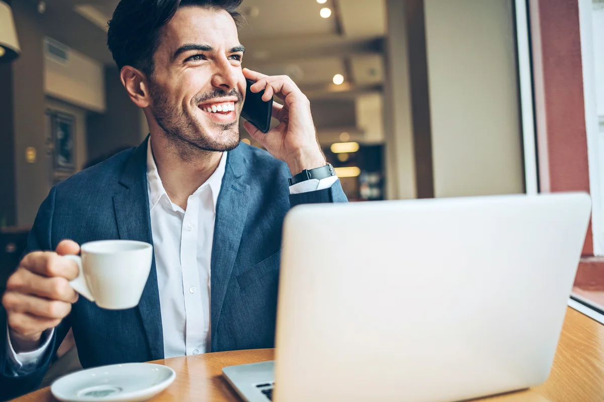 Man talking on the phone and drinking coffee