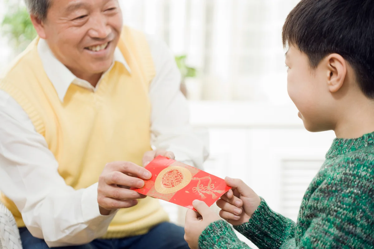 Chinese grandfather giving grandson red pocket