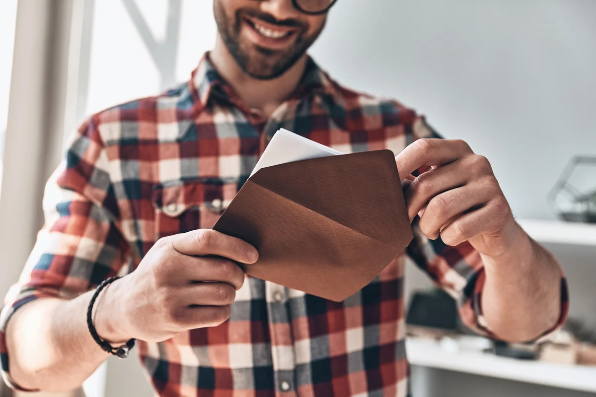 Young man opening envelope
