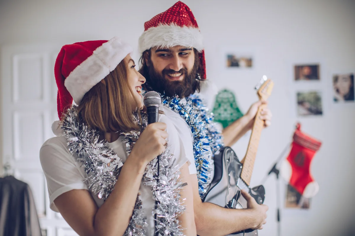 Couple singing and playing guitar at Christmas time