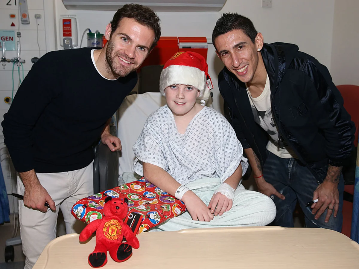 For Editorial use - Juan Mata and Angel di Maria of Manchester United pose with Brandon, 12, from Oldham as part of the club's annual Christmas visits to sick children in hospital on December 15, 2014 in Manchester, England.