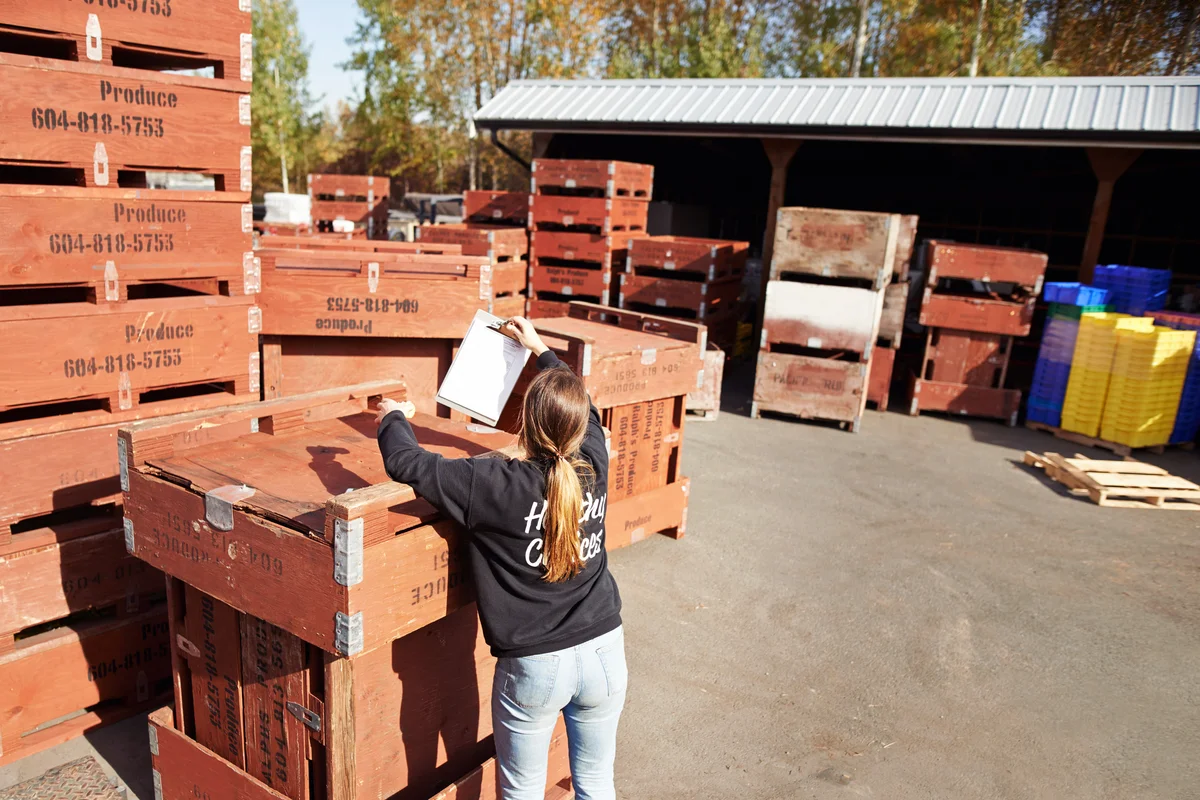 Shot of a young woman getting produce ready for delivery on a farm
