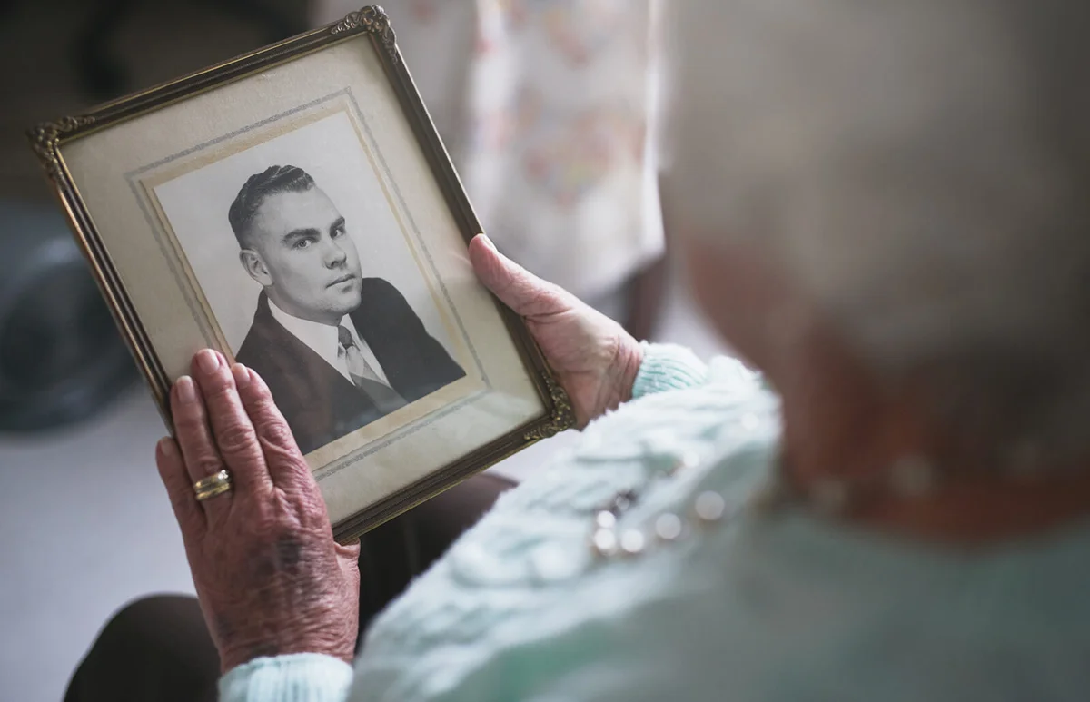 senior woman looking at an old black and white photo