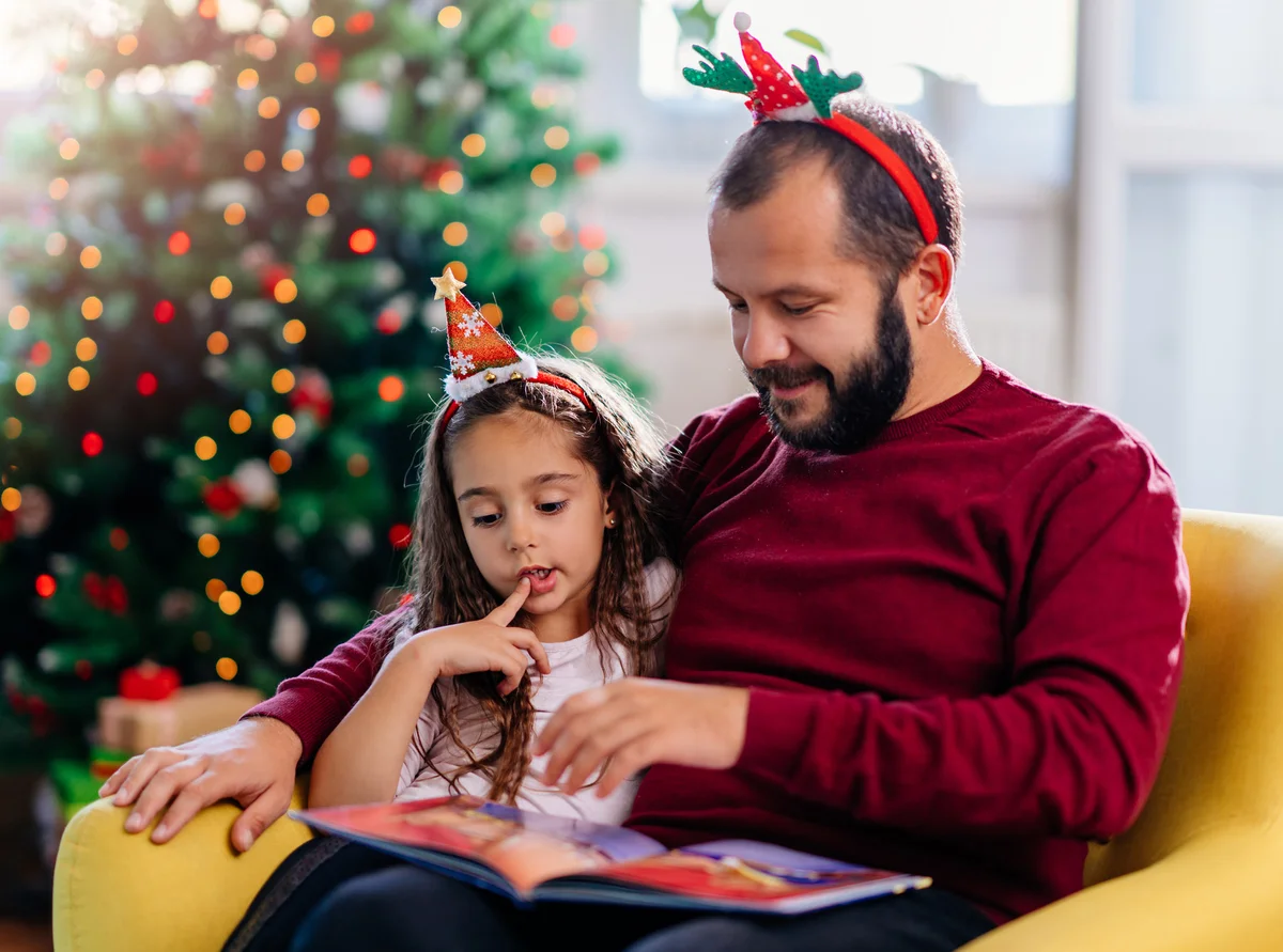 Father and his daughter reading Christmas fairy tales