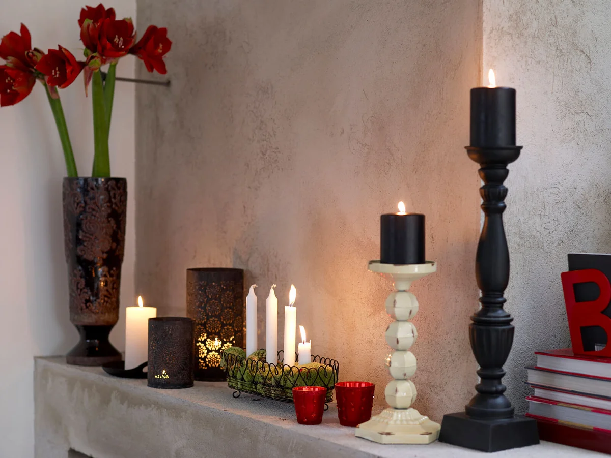 Various candles and vase on fireplace