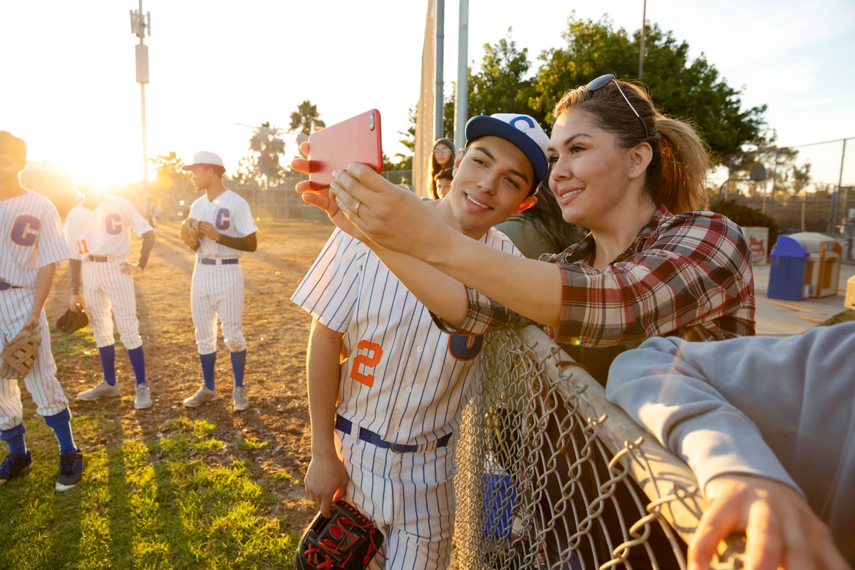 Mother and baseball player son taking selfie