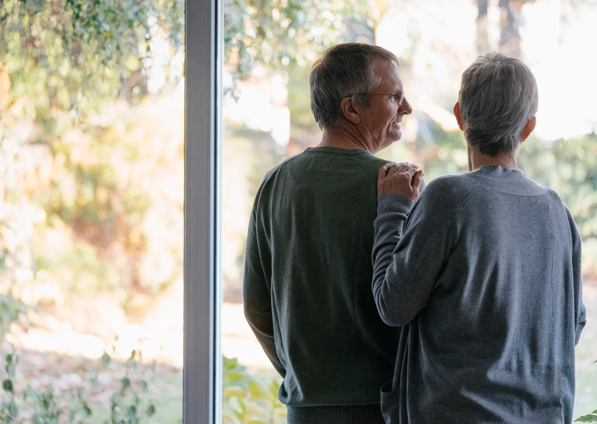 Senior couple standing at window