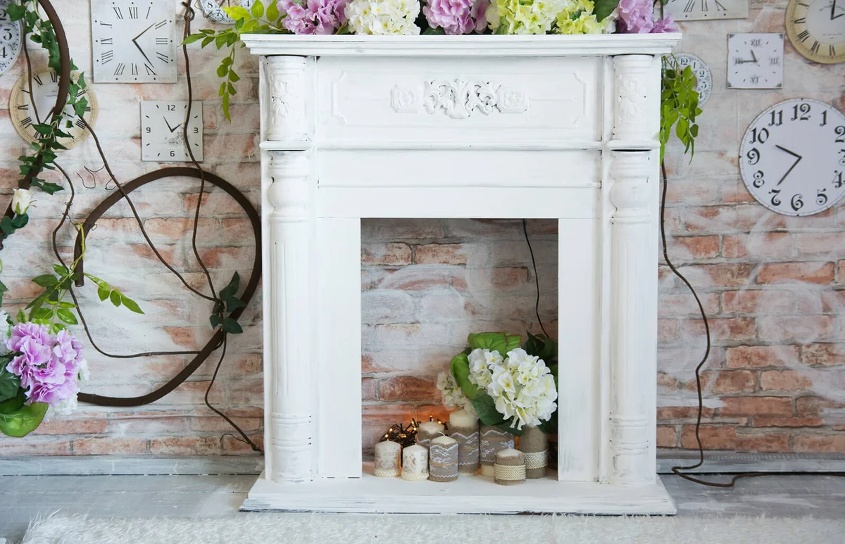 White decorative fireplace with flowers and candles | ID 140286032 © Kanzefar | Dreamstime.com