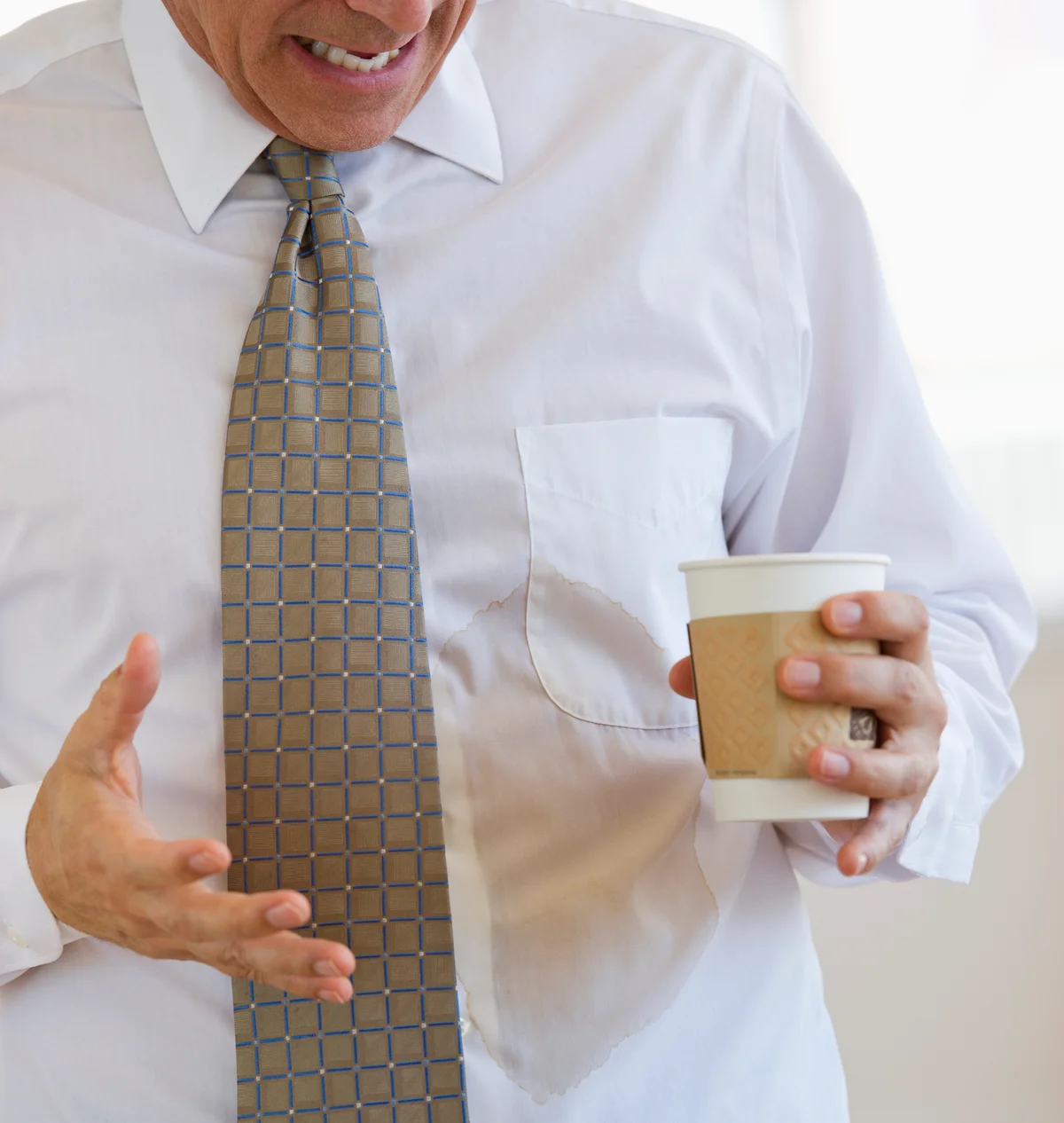 Businessman spilling coffee on shirt