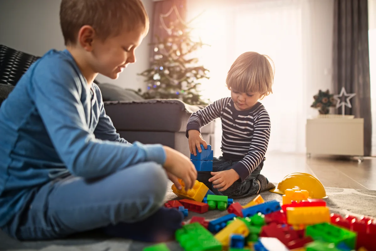 Little boys on christmas morning playing with new blocks