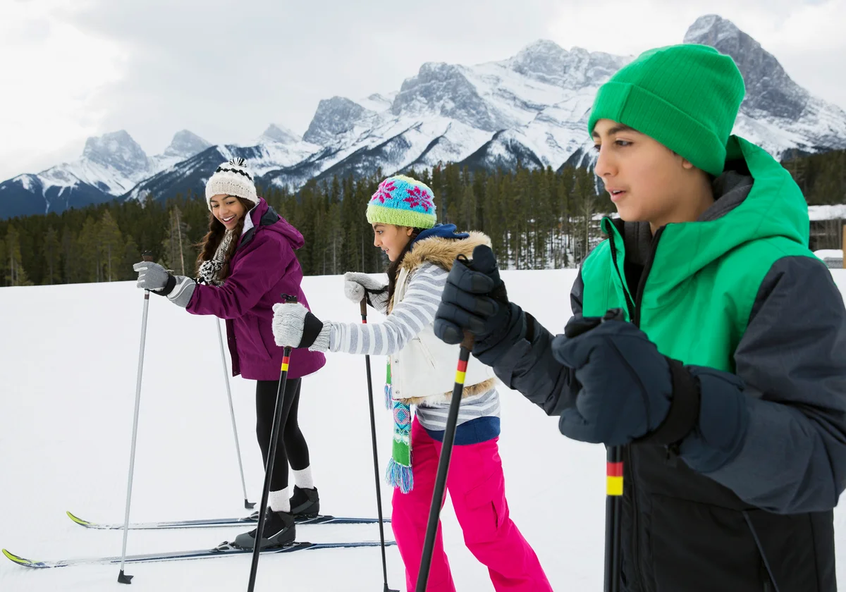 Children cross-country skiing in snowy field