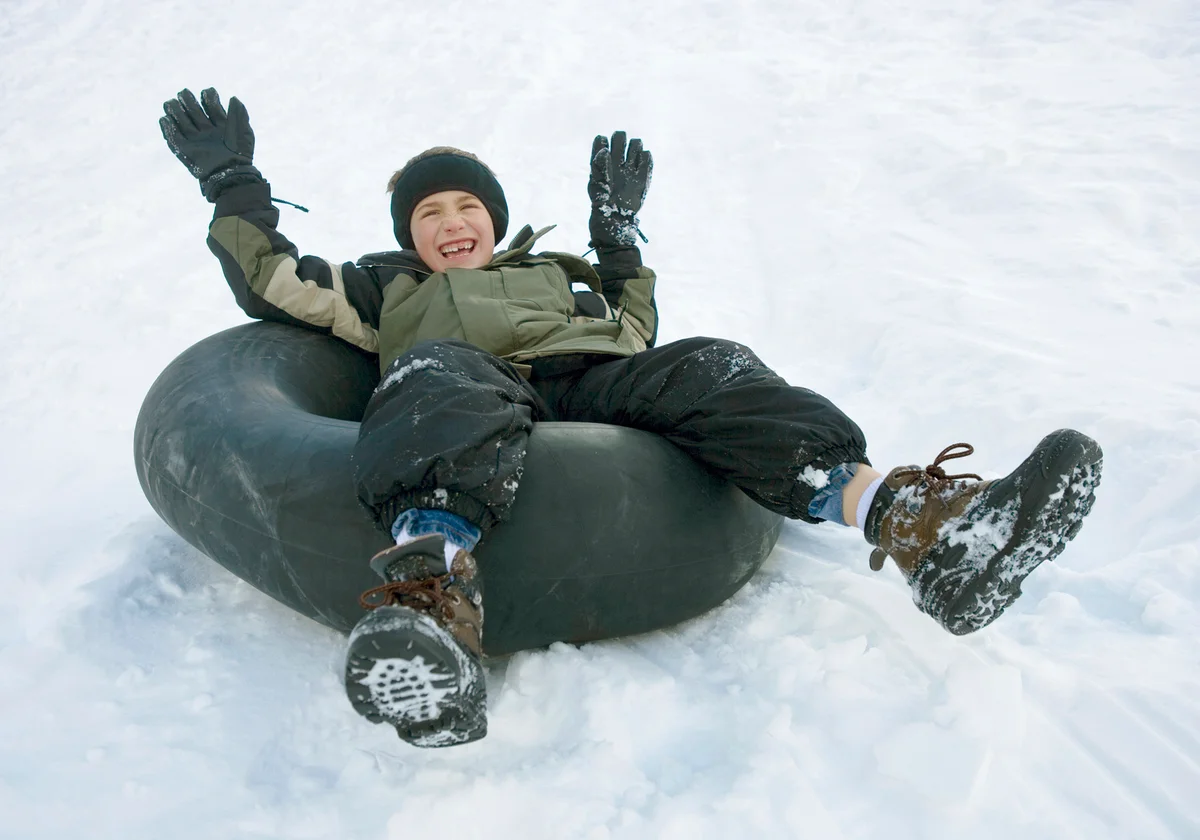 Boy going down hill on inner tube