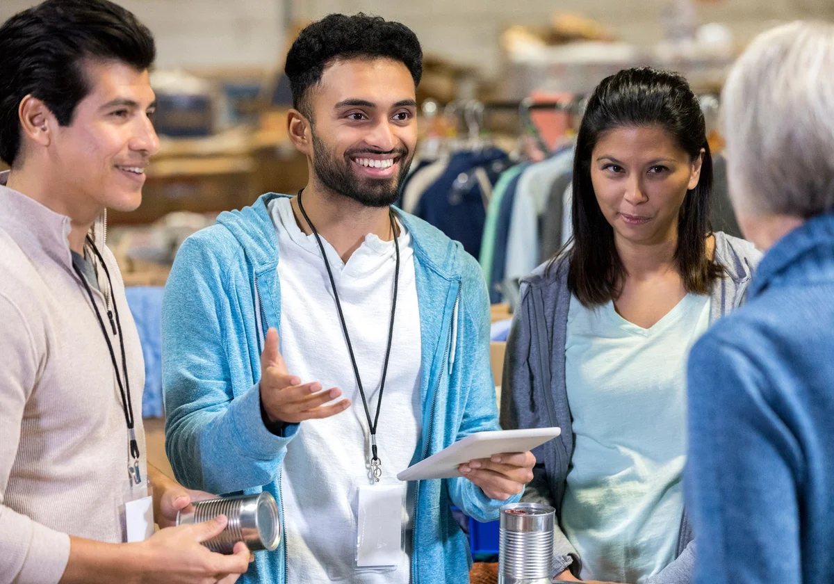 Young man organizes volunteers in food bank