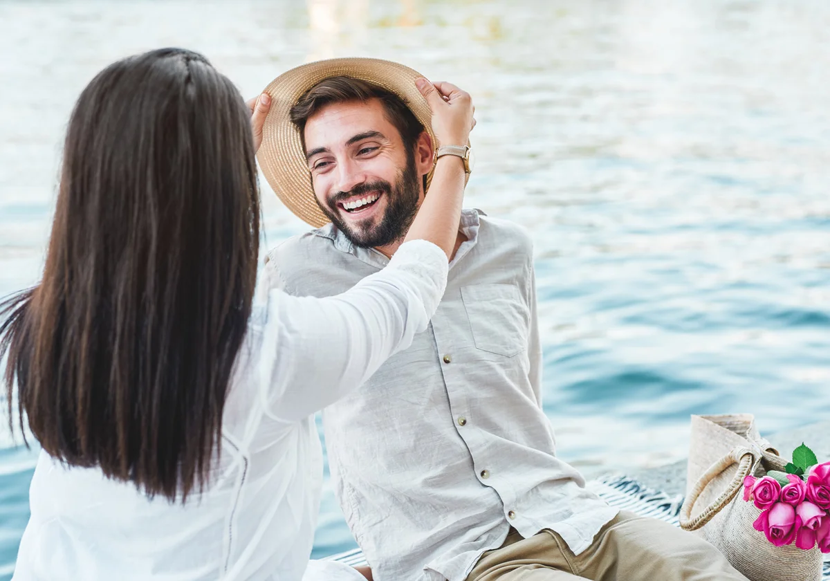 young couple having a romantic date next to the water’s edge