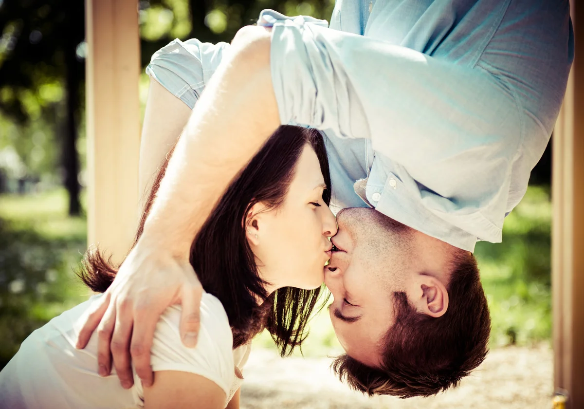 man hanging down is kissing with his girlfriend