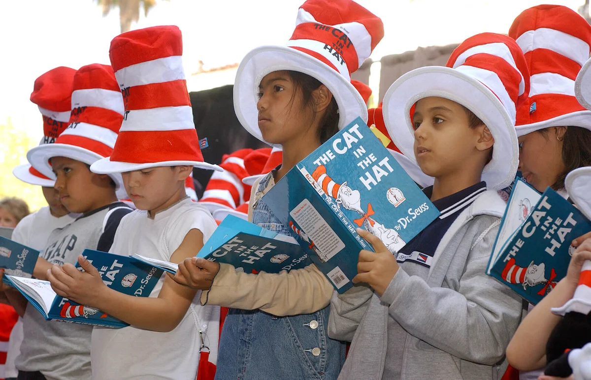 Children read from "The Cat in the Hat" book at a ceremony honoring the late children's book author Dr. Seuss | Getty Editorial Images