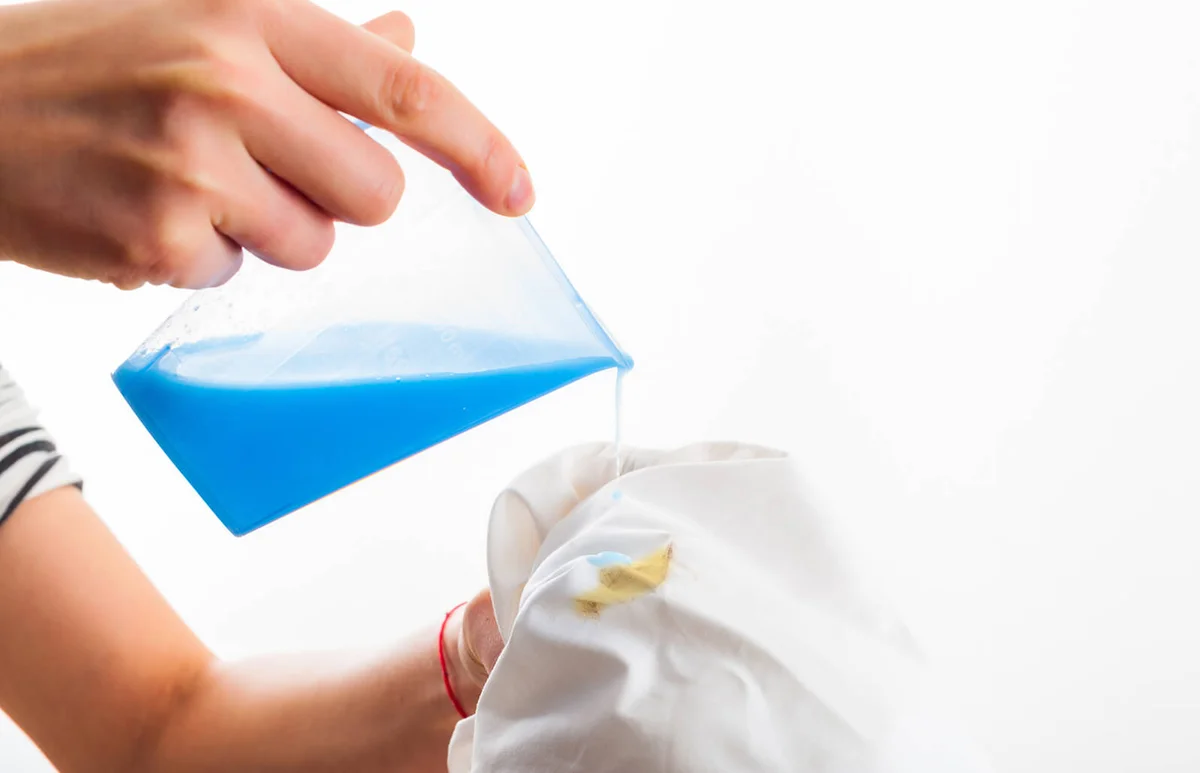 Removing stain from white shirt measuring determent by hand