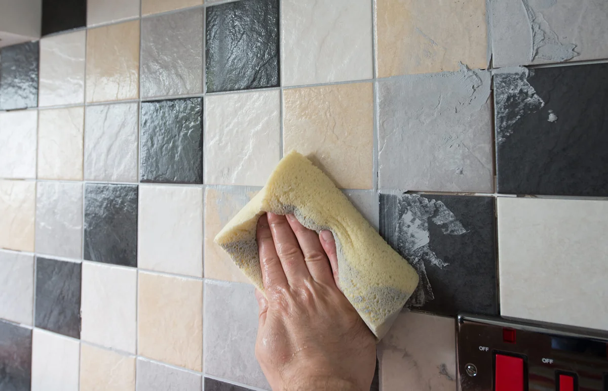 using a sponge to wipe of excess grout
