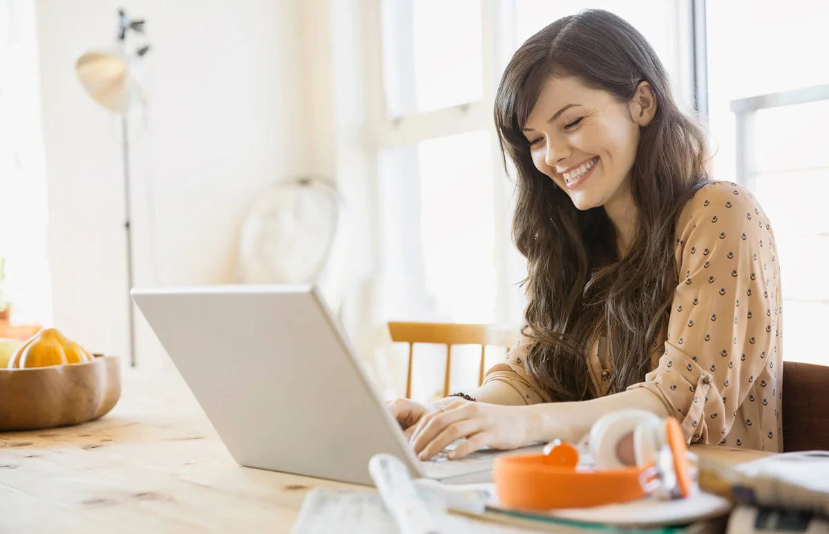Smiling woman using laptop at table