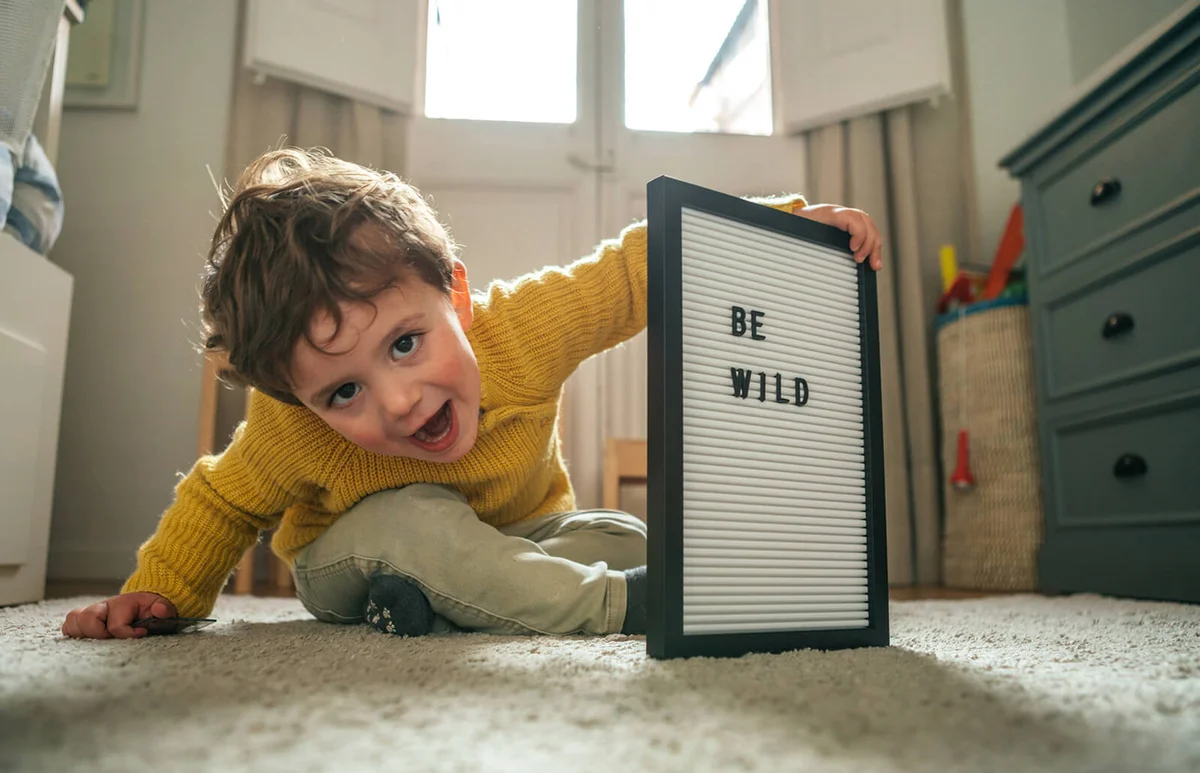 Little boy with "Be Strong" text on message board